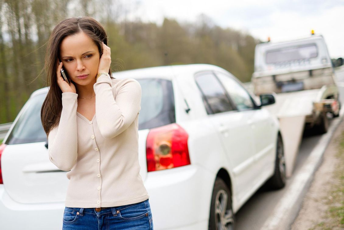 A woman broken down and having her vehicle recovered